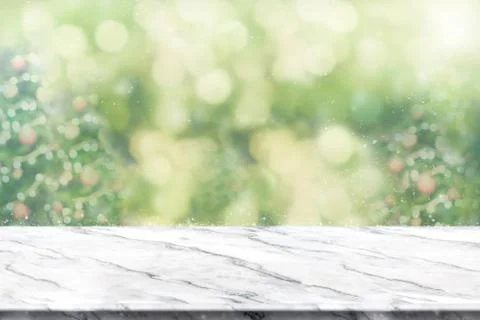 Empty white marble table top with abstract green blur christmas tree and snow Stock Photos