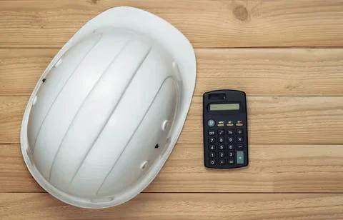 Empty white oval dish with black calculator on wooden table Stock Photos