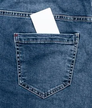 Empty white paper card in the back pocket of blue jeans Stock Photos