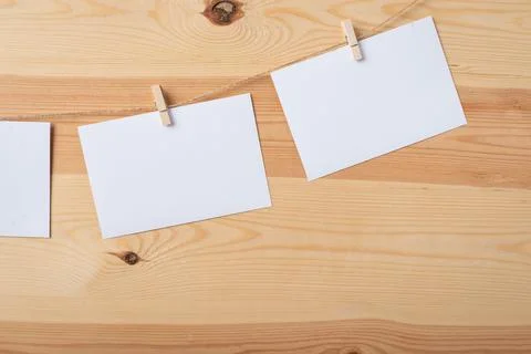 Empty white paper cards attached to the rope with clothespins Stock Photos