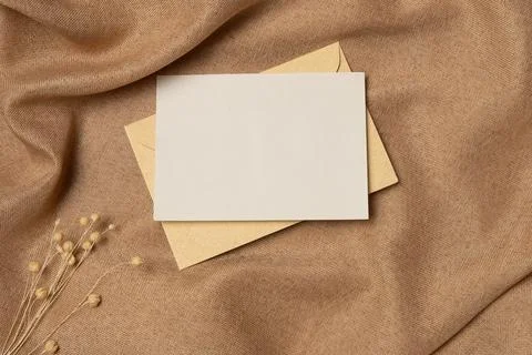 Empty white paper list with envelope on a fabric background from above. Cop.. Stock Photos