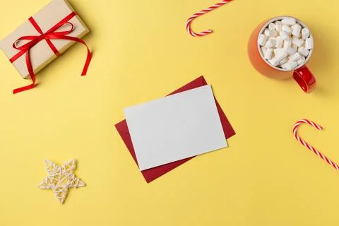 Empty white paper list with gift box, marshmallow and decorations on yellow b Stock Photos