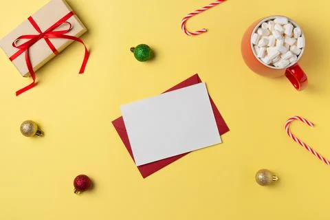 Empty white paper list with gift box, marshmallow and decorations on yellow b Stock Photos