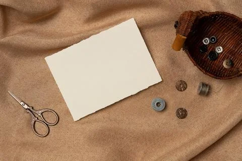 Empty white paper list with scissors and buttons on a fabric background fro.. Foto stock