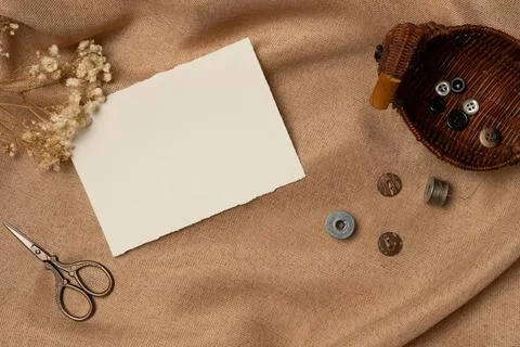 Empty white paper list with scissors and buttons on a fabric background fro.. Stock Photos