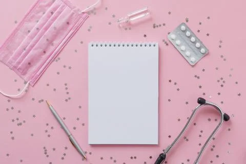 Empty white paper sheet notebook, pen, phonendoscope, medical mask, pills Stock Photos