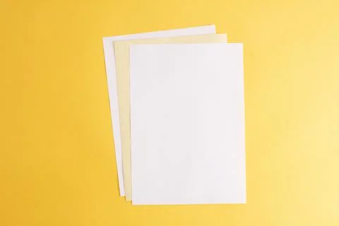 Empty white papers on the yellow background. Stock-Fotos