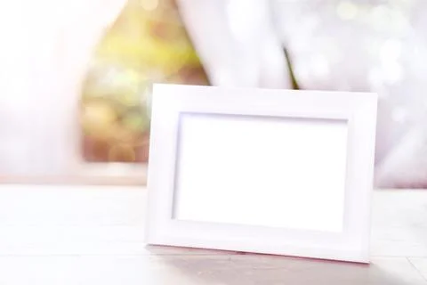 Empty white photo frame on the table Stock Photos