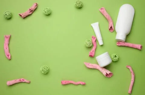 Empty white plastic tubes, jar for cosmetics on a green background. Packag... Stock Photos