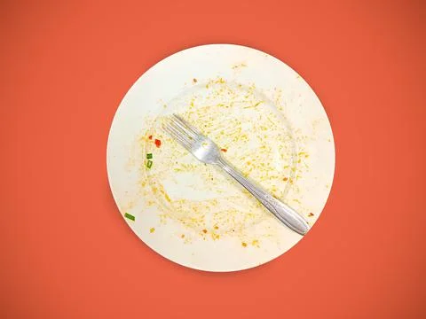 Empty White Plate With Fork And Food Scraps On Orange Background After Meal Фото