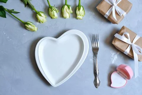 Empty white plate with hearts on Ultimate Gray background with white roses an Stock Photos