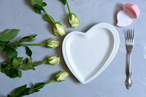 Empty white plate with hearts on Ultimate Gray background with white roses an Stock Photos