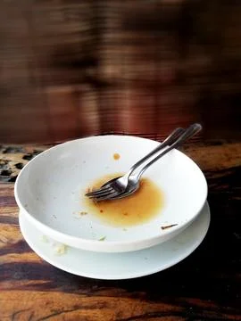 Empty white plate, placed on the brown wooden table Stock Photos