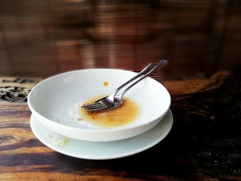 Empty white plate, placed on the brown wooden table Stock Photos