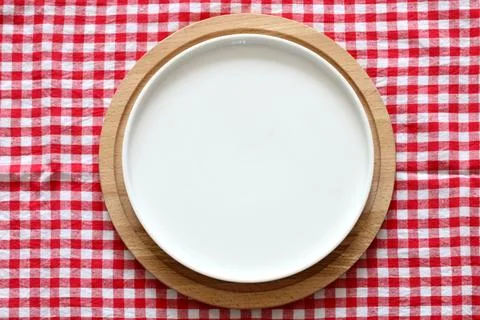 An empty white plate on a red checkered tablecloth, top view. mockup, scene c Foto stock