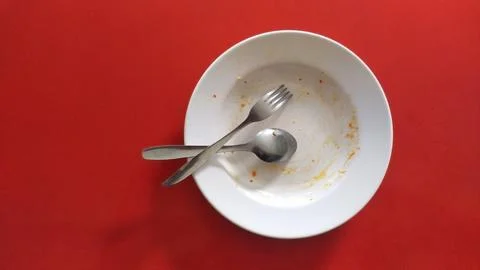 Empty white plate on the red table after eat Stock Photos