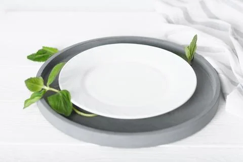 Empty white plate on a table, dinner setting, mockup for food styling Stock Photos