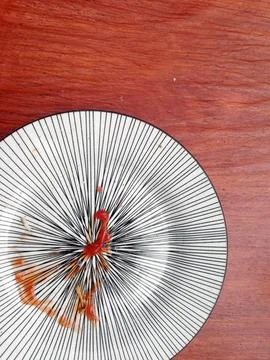 Empty white plate , with tomato ketchup , placed on the wooden table Stock Photos
