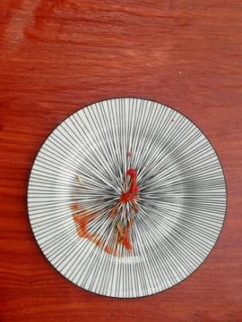 Empty white plate , with tomato ketchup , placed on the wooden table Stock Photos