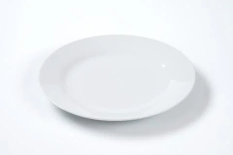 Empty white plate on off-white background Stock Photos