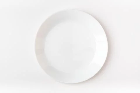 An empty white plate on a white background. Blank plate. Top view. Stock Photos