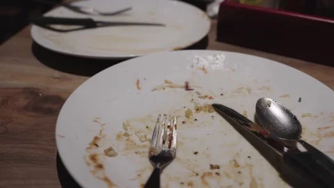 Empty white plates with food scraps and used silverware on a rustic wooden .. 库存影片 342250409