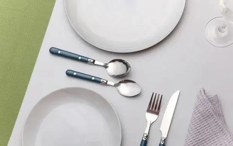 Empty white plates fork knife spoon on table setting Stock Photos