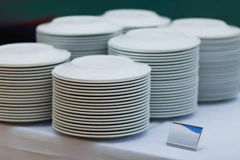 Empty white plates stacked on table Stock-Fotos