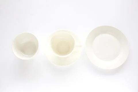 Empty white plate,white cup and white bowl on white background Stock Photos