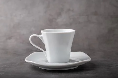 Empty white porcelain cup on gray stone background Stock Photos