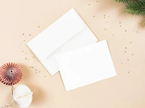 Empty white postcard and envelope and various christmas decor on beige back.. Stock Photos