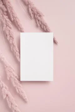 Empty white poster or card mockup with dried grass decoration on light back.. Stock Photos