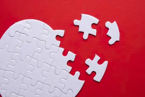 Empty white puzzle with missing pieces on red background Foto stock