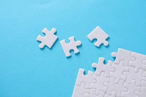 Empty white puzzle pieces on blue background Foto stock