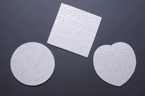 Empty white puzzle pieces on dark background Foto stock