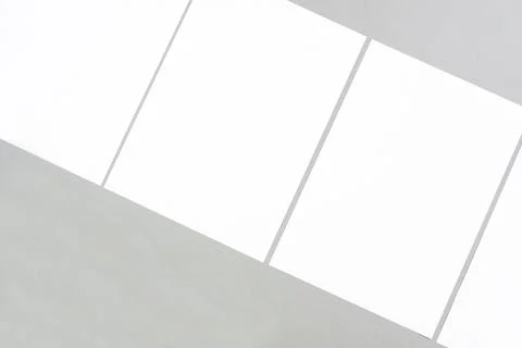 Empty white rectangle poster mockups lying diagonally on a gray background Stock Photos