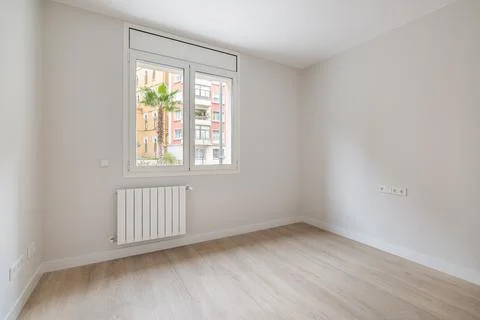 Empty white room with heating and window with city view. Interior of a modern Stock Photos