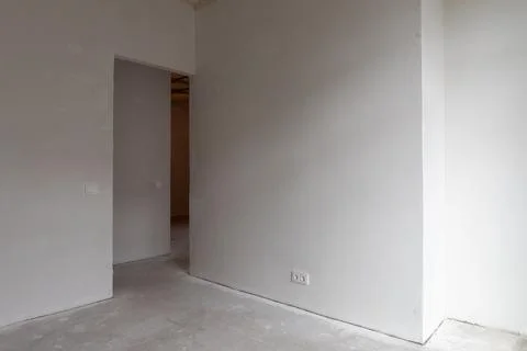 Empty white room with open doorway and bare floor in a minimal interior. Un.. Stock Photos