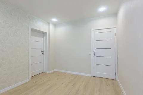 Empty white room with two doors and wooden floor Stock Photos