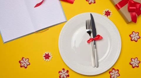 Empty white round plate, fork and knife on yellow background, top view Stock Illustration
