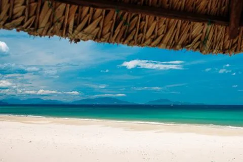Empty white sand beach and parasol, blue sky Stock Photos