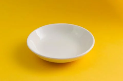 Empty white sauce dish plate with isolated yellow background Stock Photos