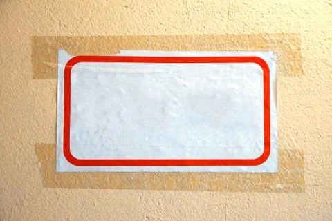 Empty white sheet of paper with a red frame. Glued tape to the wall. Stock Photos