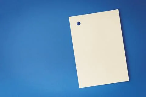 Empty white sheet is pinned with a button on blue background Stock Photos
