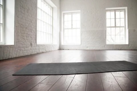 Empty white space, loft studio, yoga mat on the floor Stock Photos
