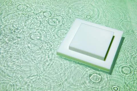 Empty white square podium on transparent green clear water background Stock Photos