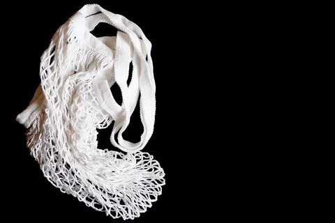 An empty white string mesh bag is isolated on a black background. space for t Stock-Fotos