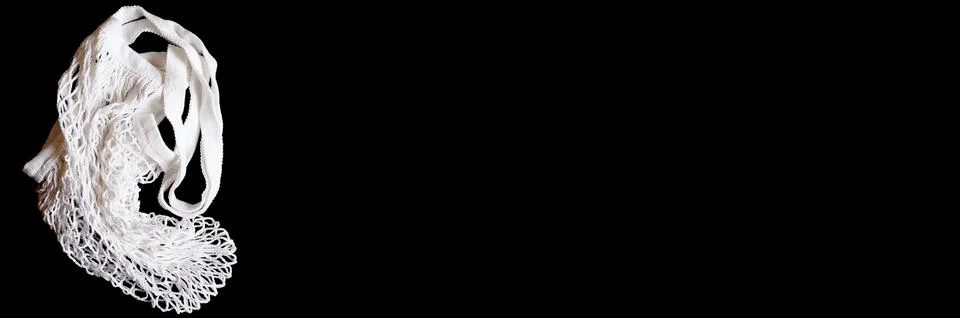 An empty white string mesh bag is isolated on a black background. space for t Foto stock