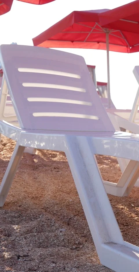 Empty white sun loungers on the beach under red umbrellas Stock Footage 307167959