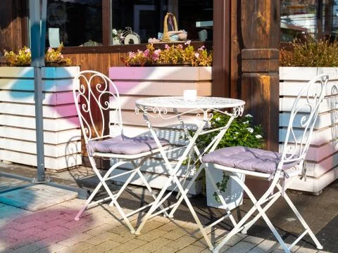 Empty white table and couple chairs on street outside a cafe bar or restaurant Stock Photos